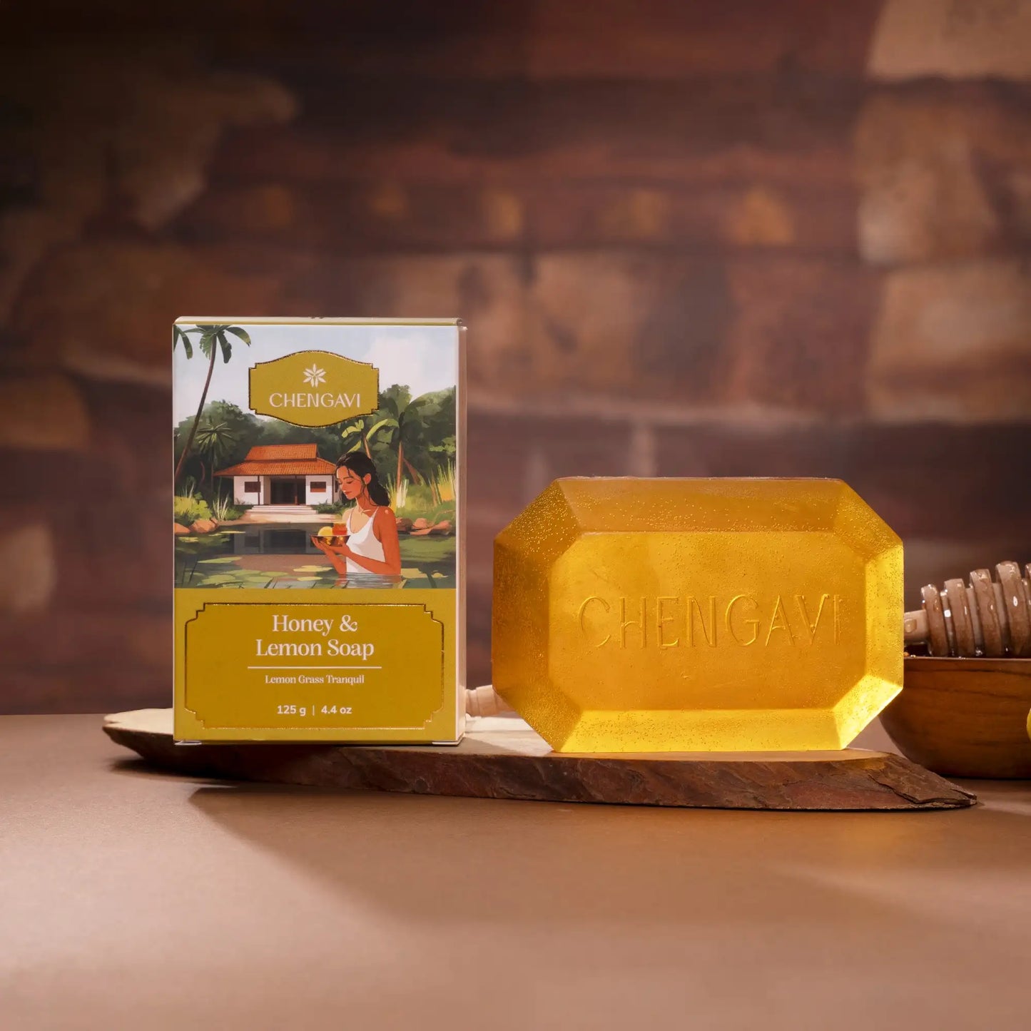 Chenigavi Honey & Lemon Soap with packaging on a wooden surface against a stone wall background