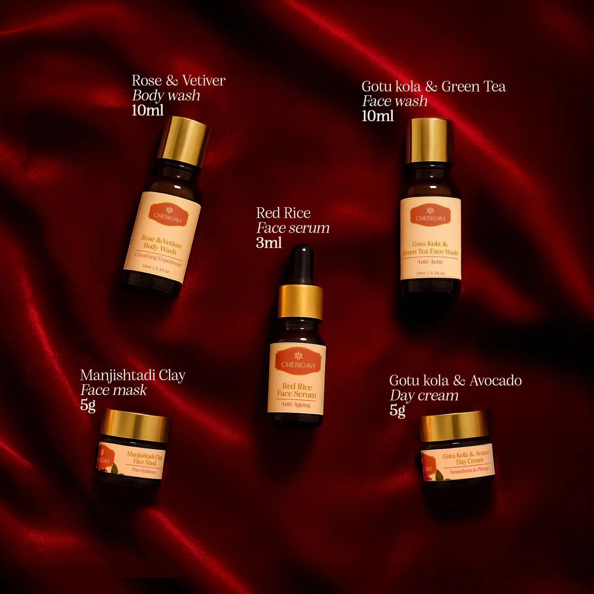 Collection of Manjushadi skincare products on a red fabric background
